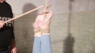 Жесткий BDSM: Связанная шлюха получает жесткую порку палкой по ступням от грубого мужика