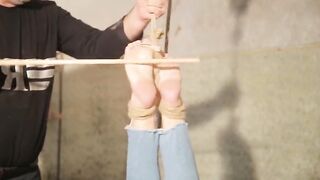 Жесткий BDSM: Связанная шлюха получает жесткую порку палкой по ступням от грубого мужика